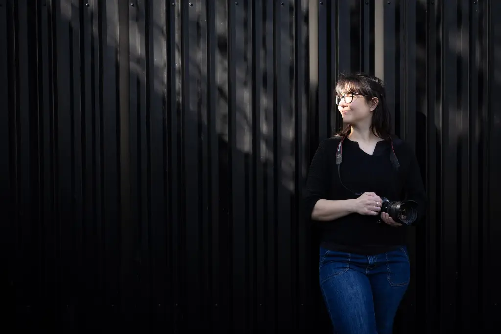 fotograaf tegen een muur steunt en kijkt in het licht