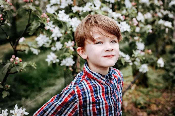 Broer en zus genieten van communieshoot tussen bloesems