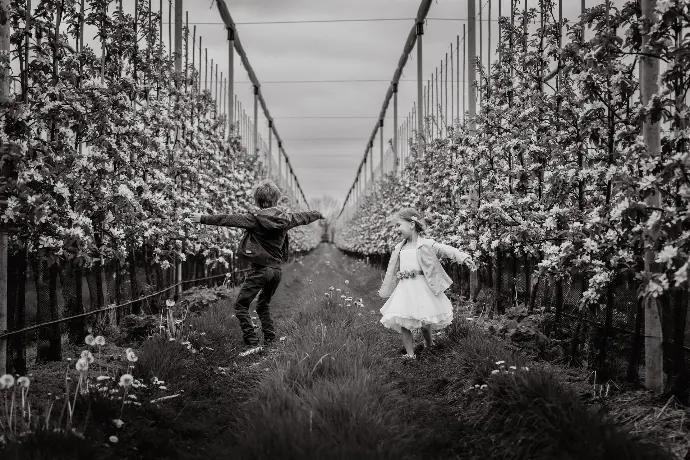 Communie fotosessie met broer en zus in kleurrijke bloesems