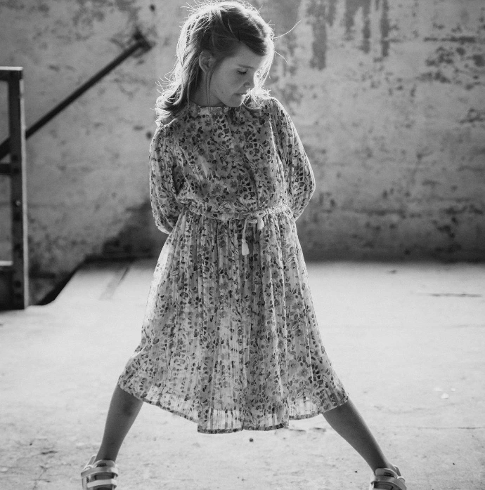 stoere meisje die in fabrieksgebouw naar haar voeten kijkt