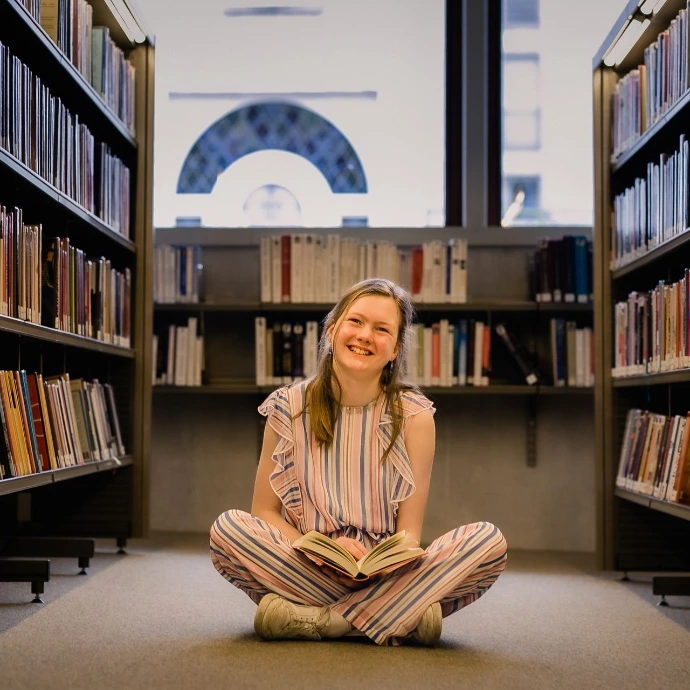 Communiefoto van kind in moderne bibliotheek van Waregem, omringd door boekenrekken en natuurlijk licht