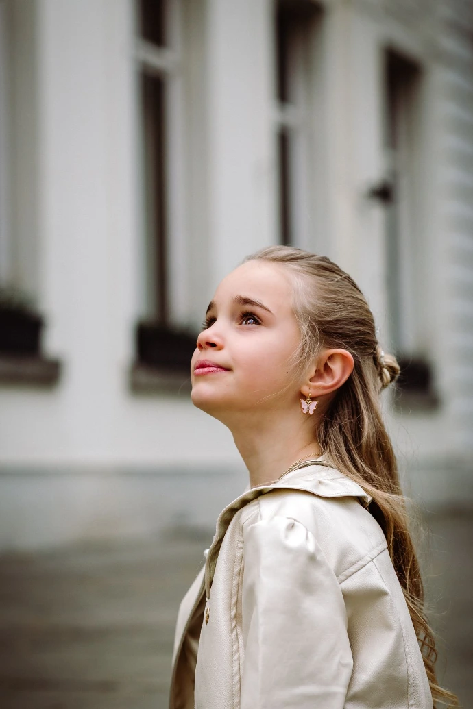 Communicant poseert met bloemen en wit jurkje
