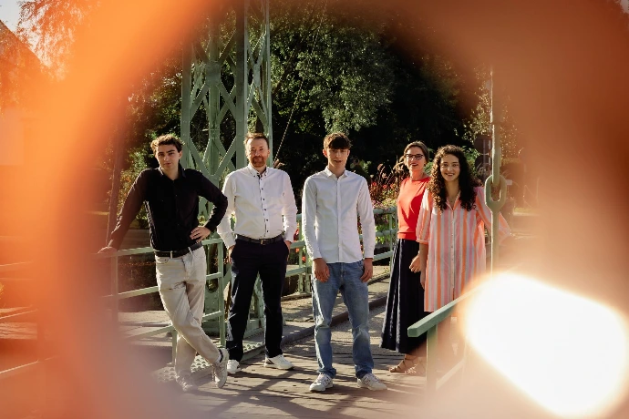 Familie lacht samen tijdens een ongedwongen fotosessie in de natuur