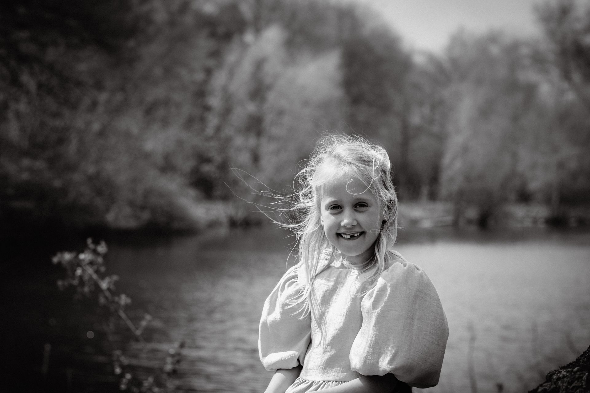 Meisje in communiekleed poseert in idyllische natuur