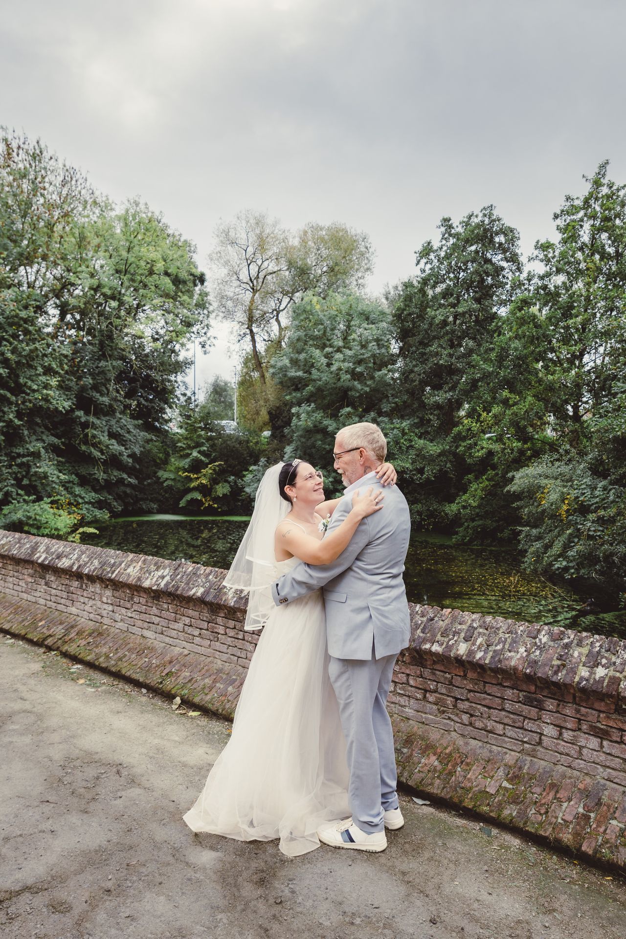 Liefdevolle after wedding reportage in Dendermonde stadspark, spontane momenten in trouwkleding.