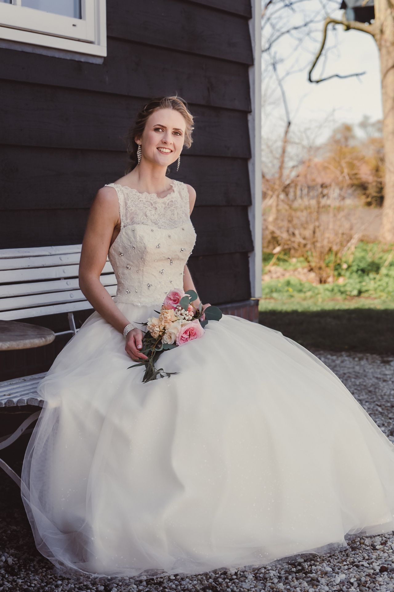 Bruid in sprookjesachtige witte trouwjurk tijdens romantische fotoshoot op landgoed.