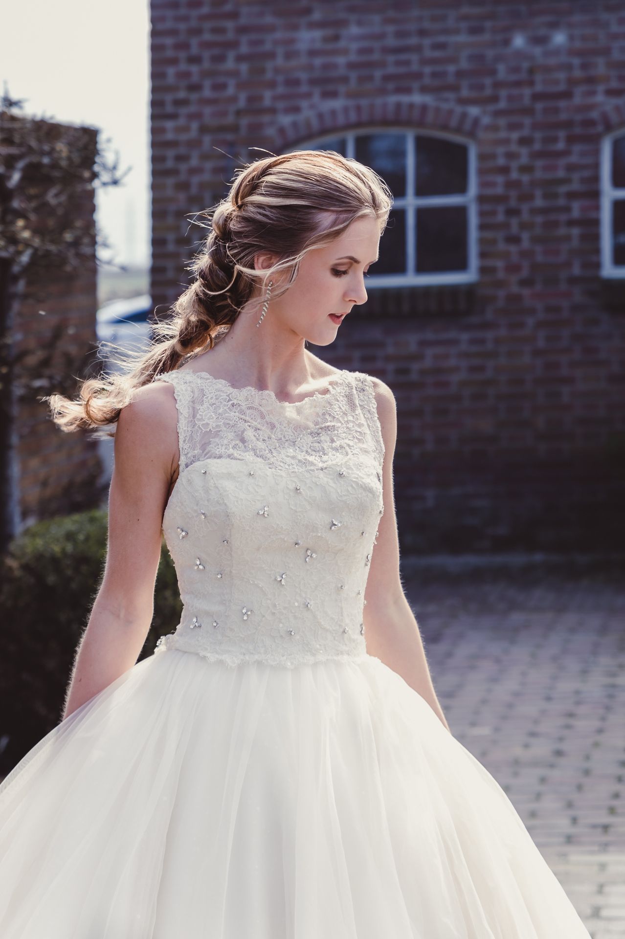 Elegante bruid in Assepoester-stijl trouwjurk, vastgelegd in natuurlijk licht.