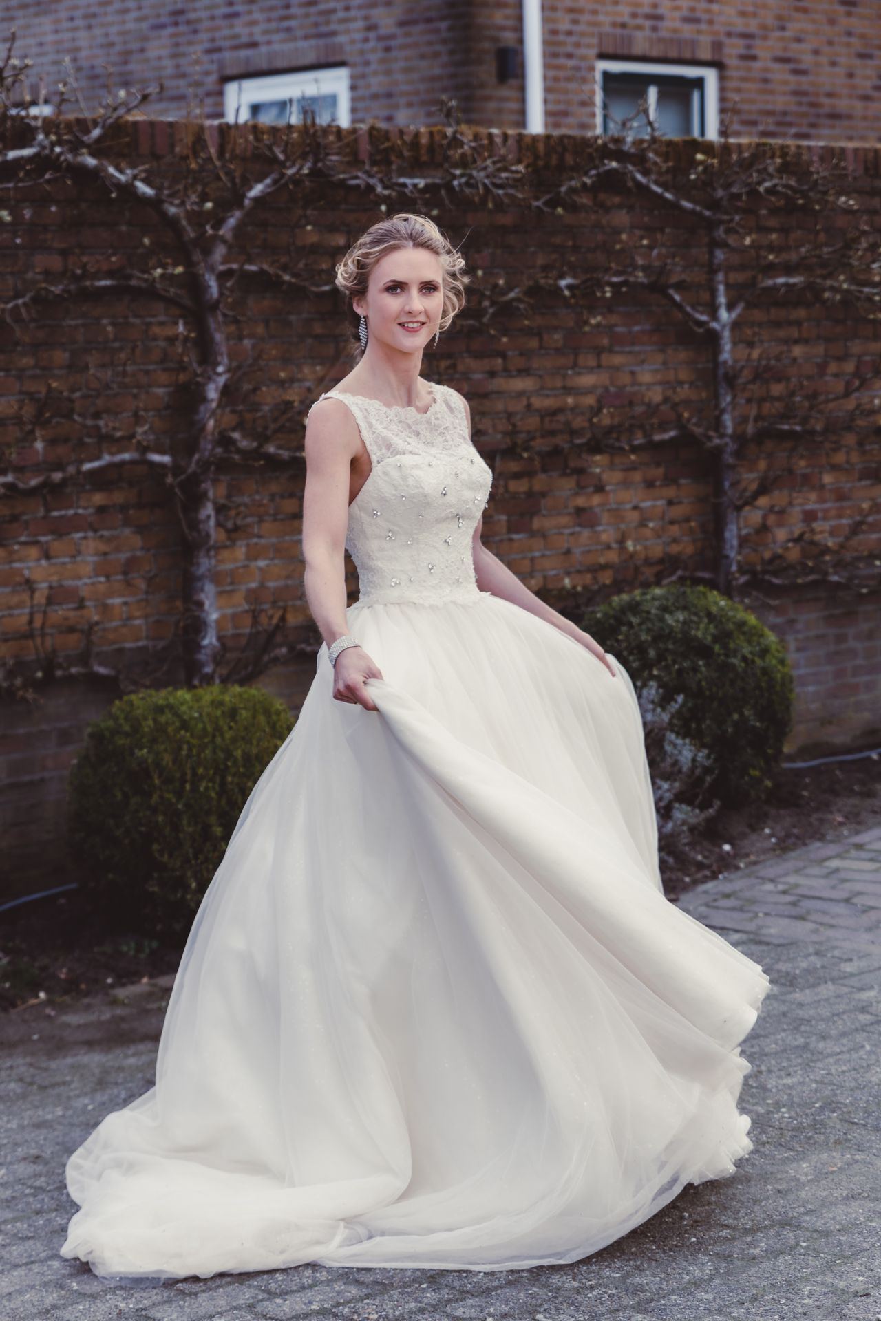 Elegante bruid in Assepoester-stijl trouwjurk, vastgelegd in natuurlijk licht.