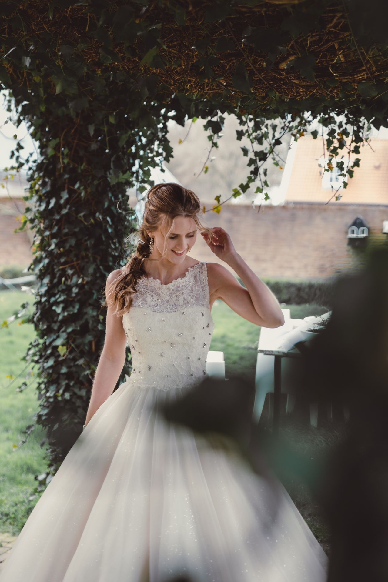 Elegante bruid in Assepoester-stijl trouwjurk, vastgelegd in natuurlijk licht.