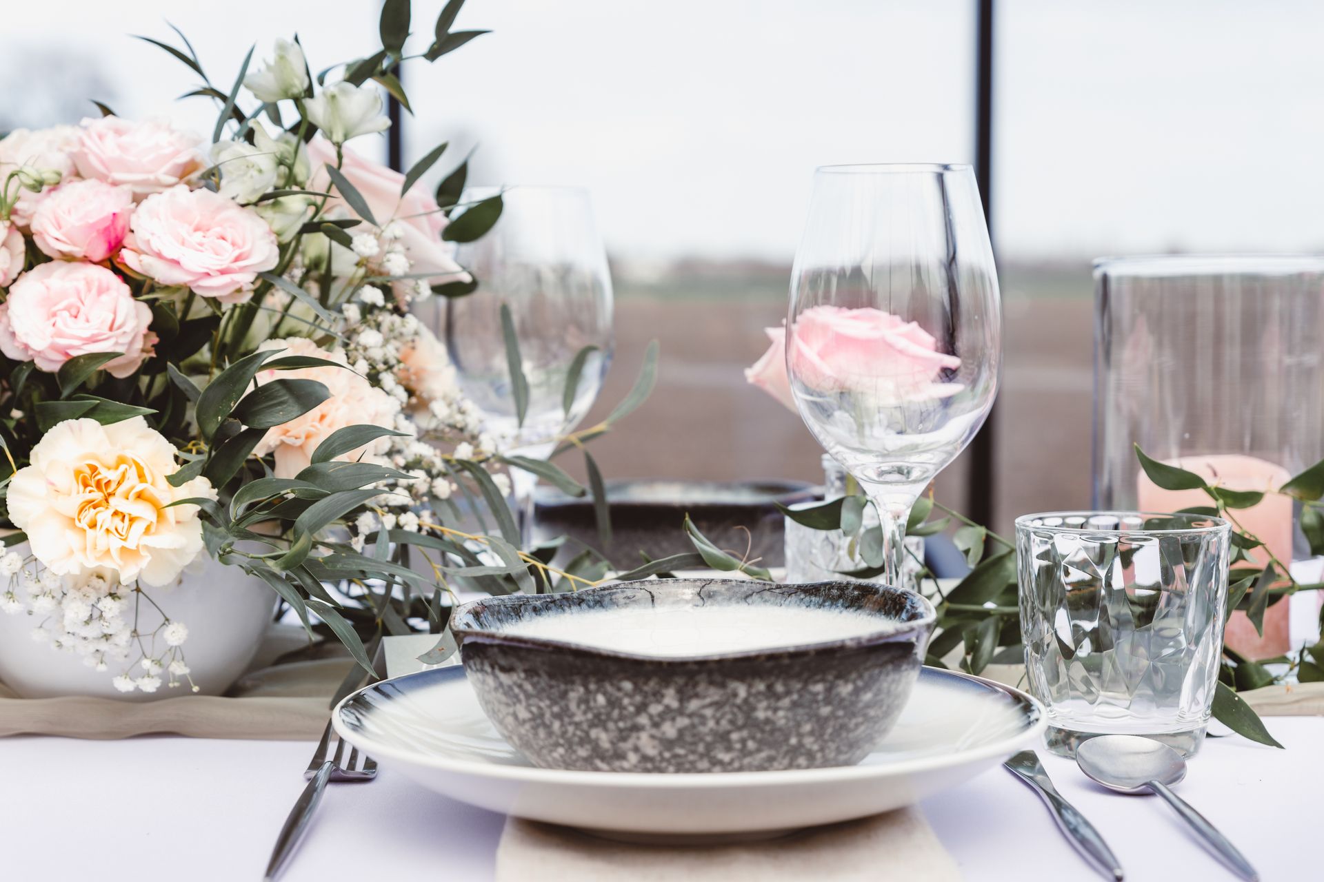 Bruid in sprookjesachtige witte trouwjurk tijdens romantische fotoshoot op landgoed.