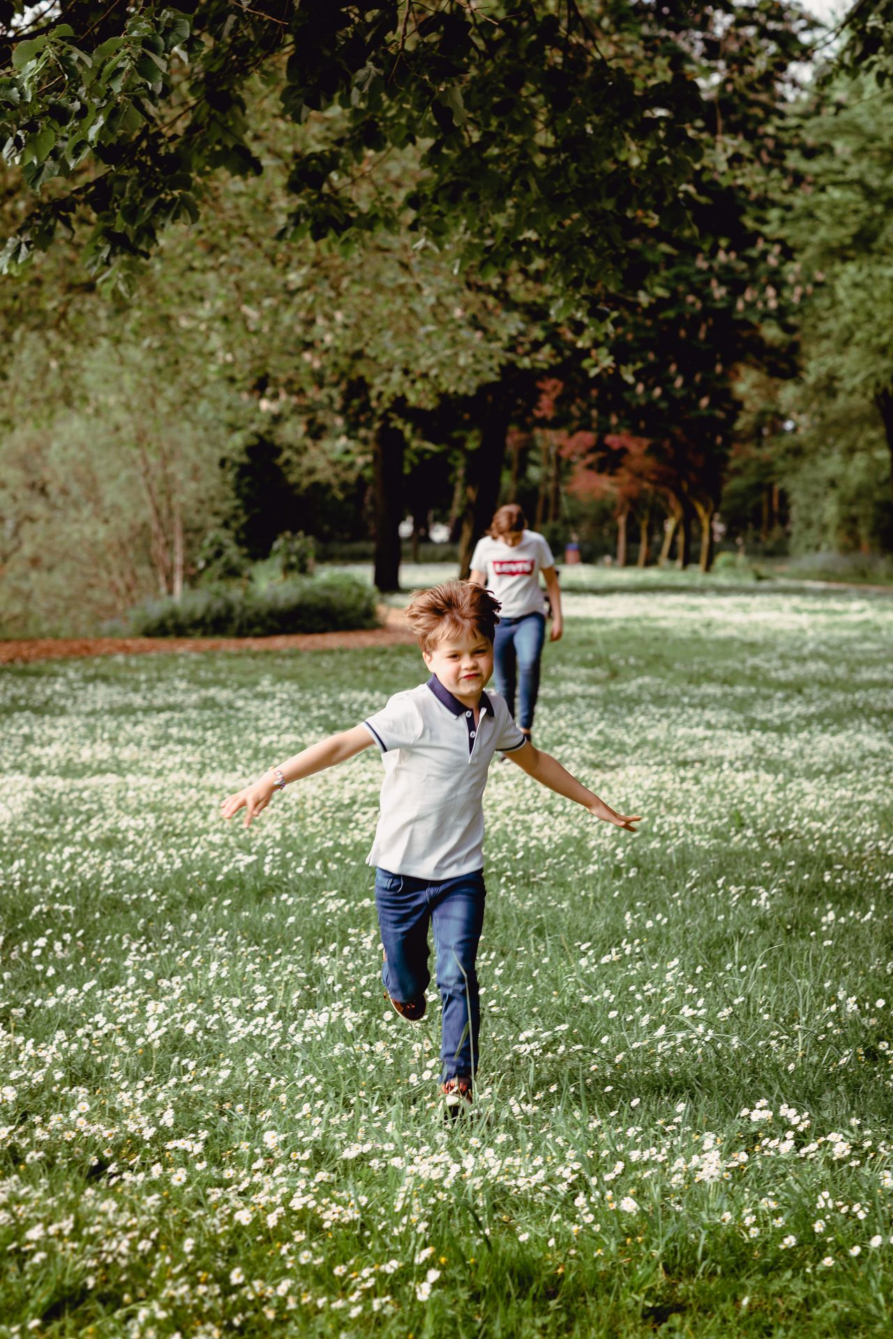 Familiefotoshoot in zonovergoten veld met hoge wolken en warme sfeer.