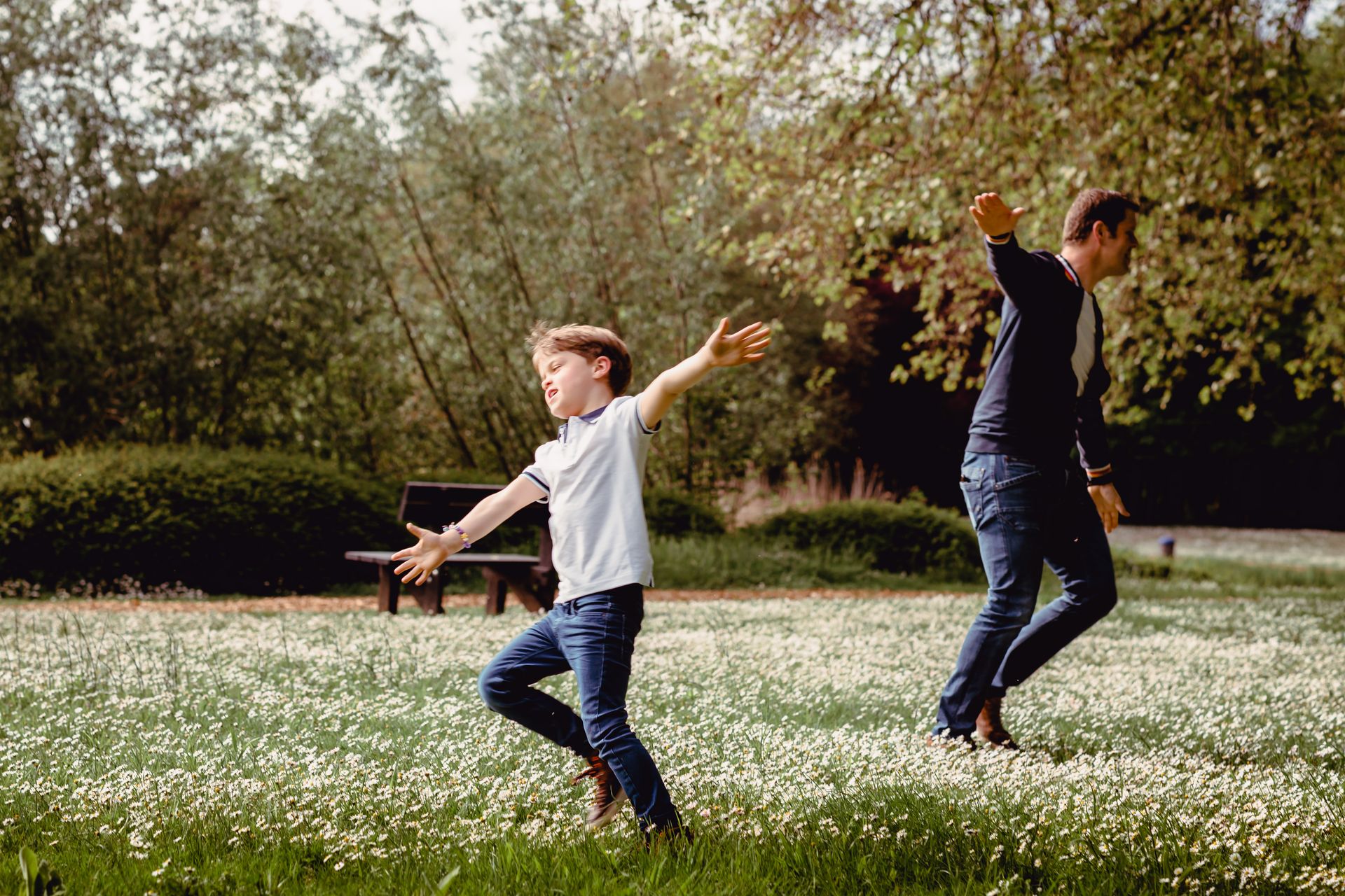Familiefotoshoot in zonovergoten veld met hoge wolken en warme sfeer.