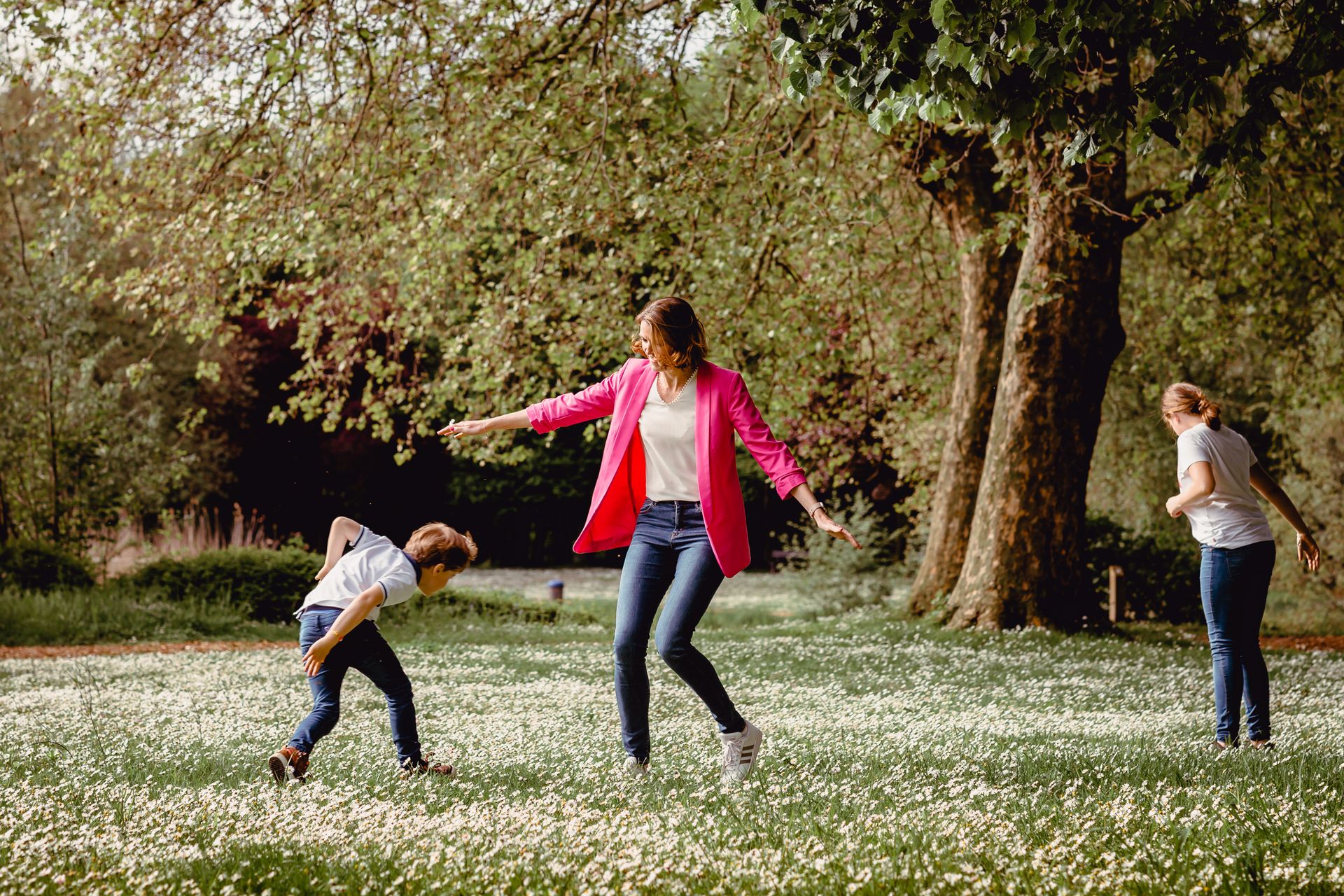 Familiefotoshoot in zonovergoten veld met hoge wolken en warme sfeer.