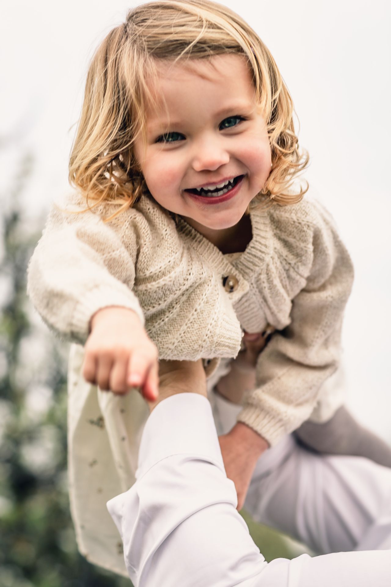 Tijdloze familiefotografie in appelboomgaard met bloesems en lichte regenbuien