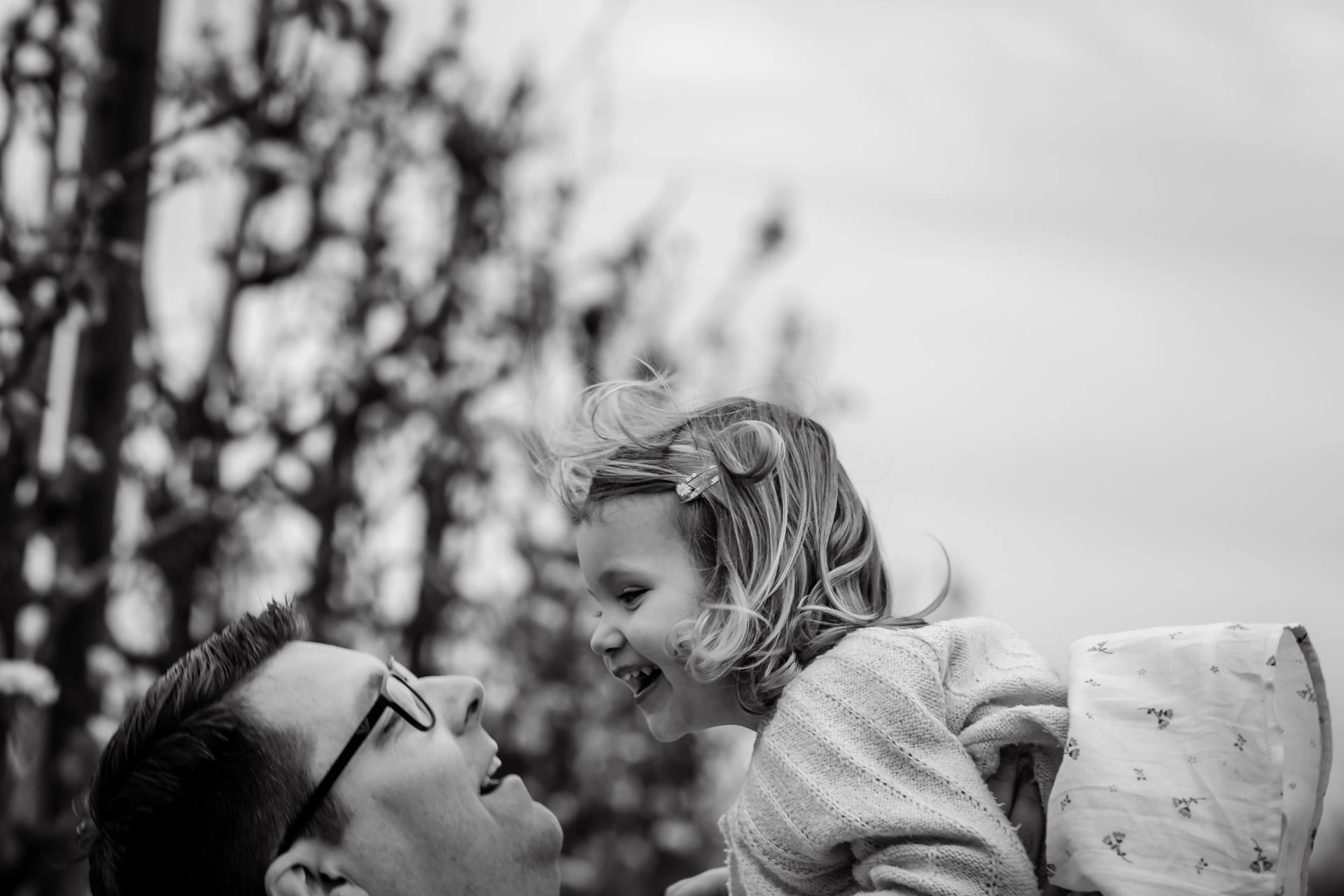 Fotoshoot van gezin in appelboomgaard, bloeiende bomen en Belgische lenteweer