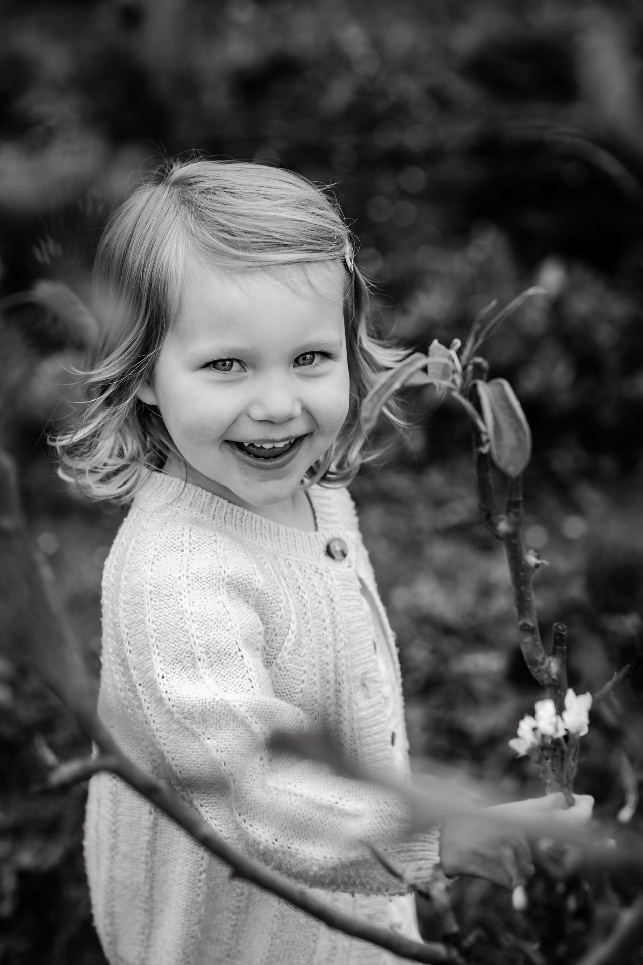 Romantische familiefoto’s in appelboomgaard met bloesems en speelse regendruppels.