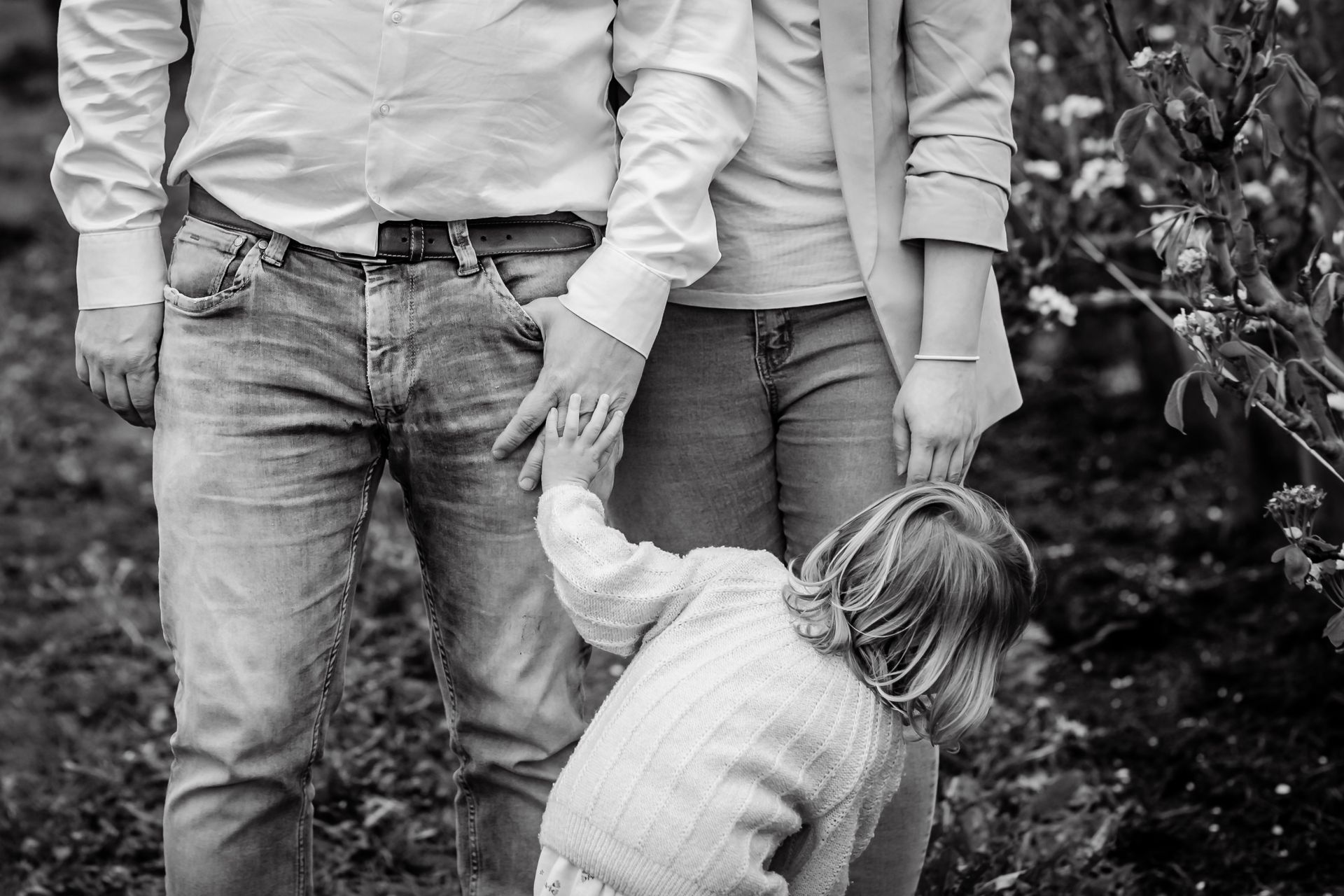 Romantische familiefoto’s in appelboomgaard met bloesems en speelse regendruppels.