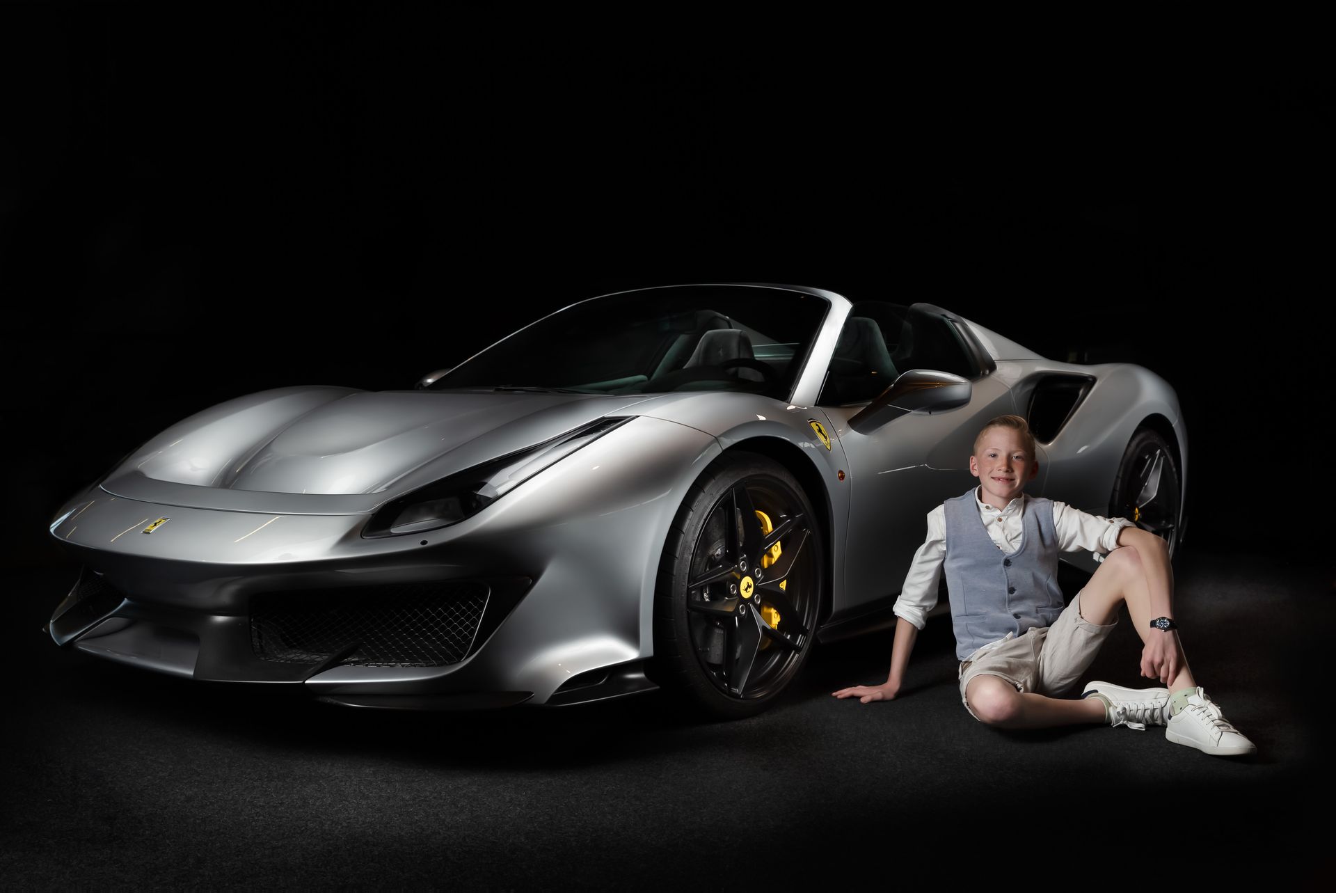 Luxe studiofoto van een zilveren Ferrari 488 Pista Spider met professionele belichting.