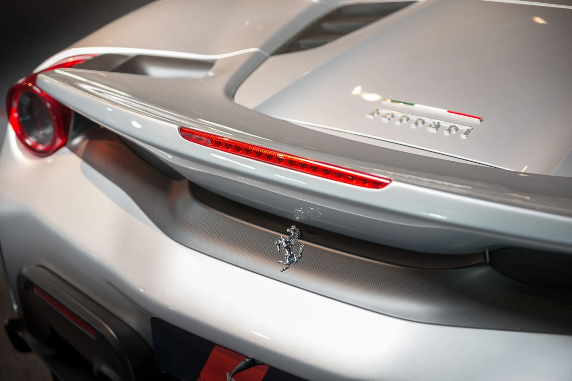 Luxe studiofoto van een zilveren Ferrari 488 Pista Spider met professionele belichting.