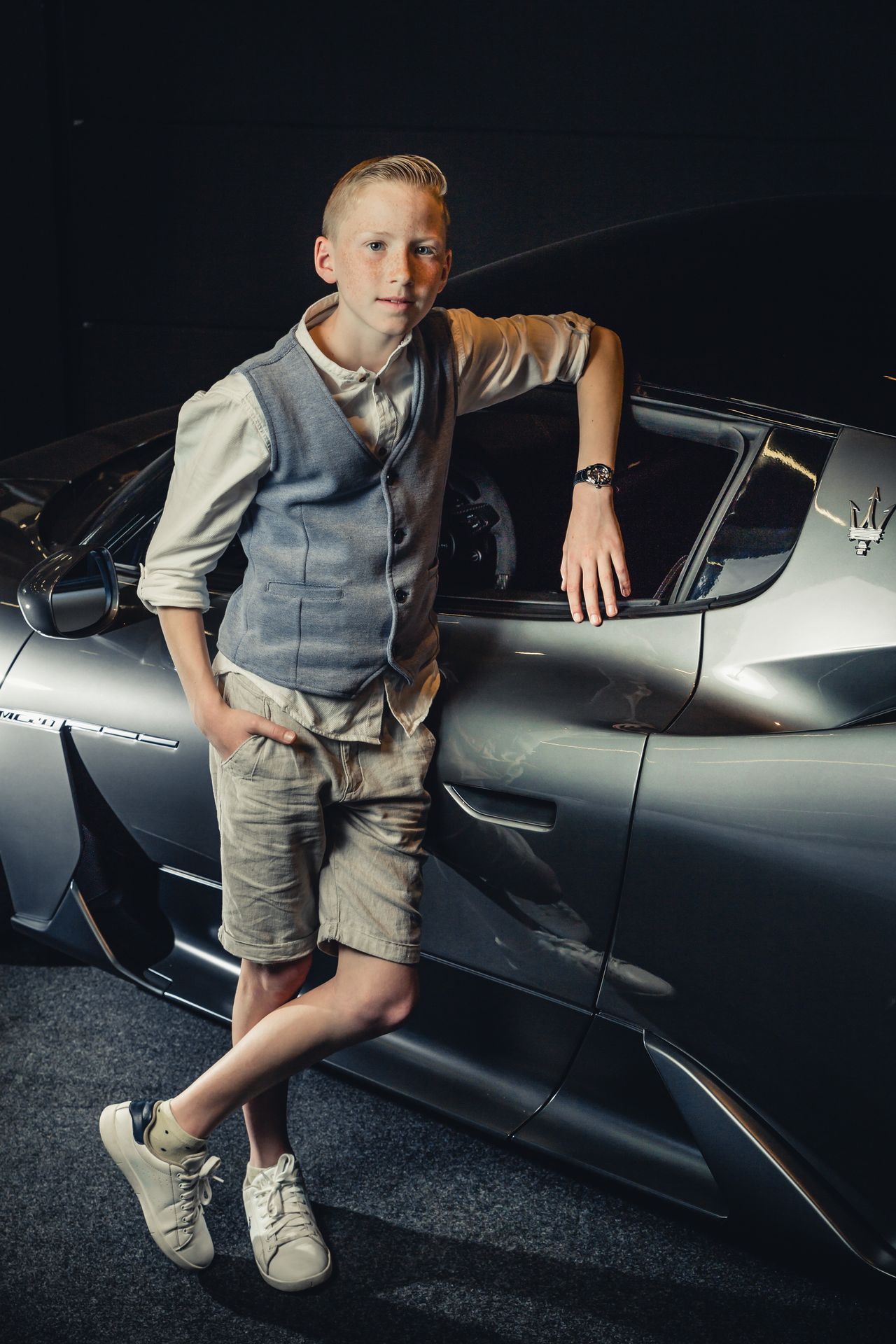 Vooraanzicht van een Maserati MC20 in een donkere studio-opstelling met dramatische belichting.