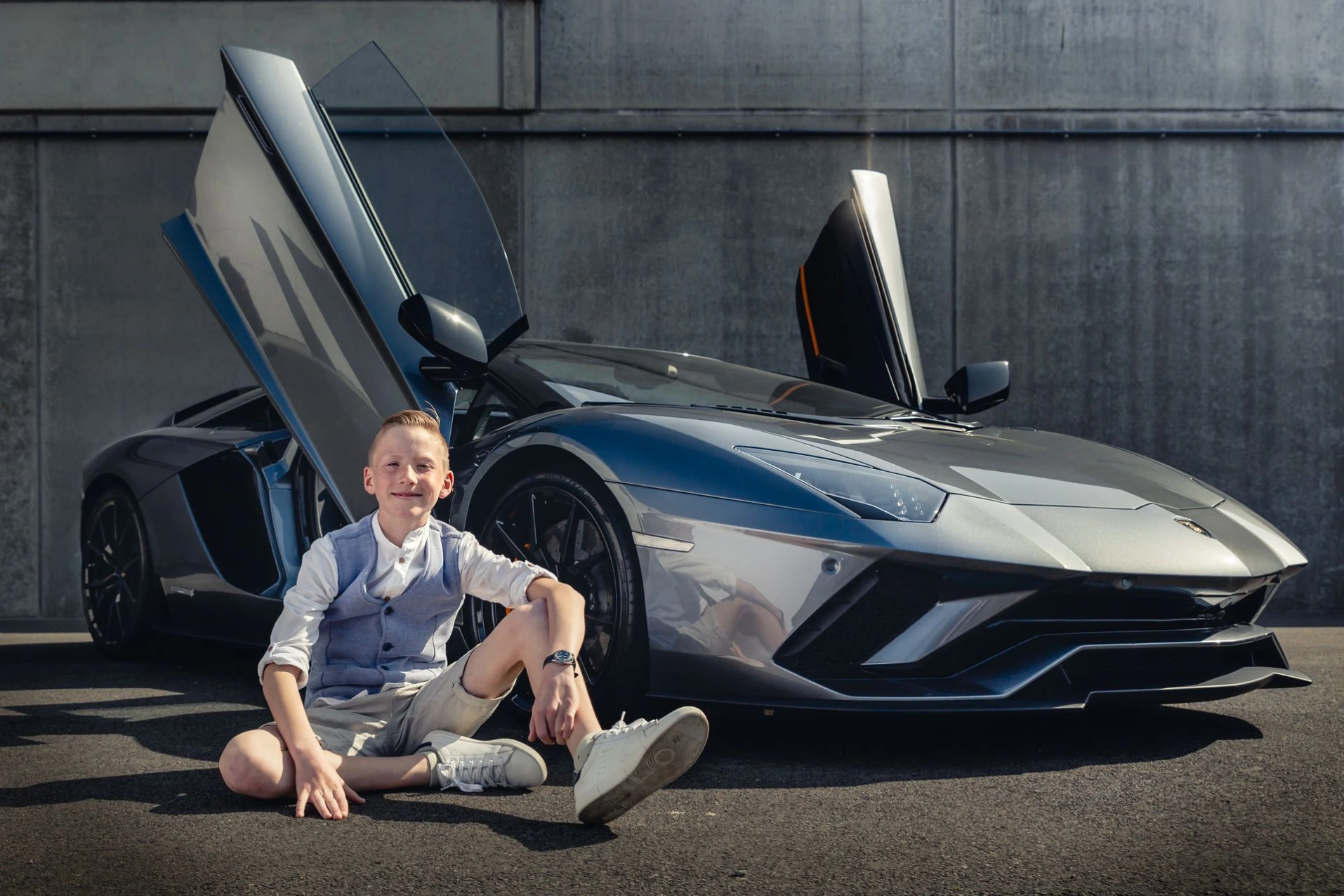 Communieshoot met een zilveren Lamborghini Aventador Roadster met openstaande vleugeldeuren.