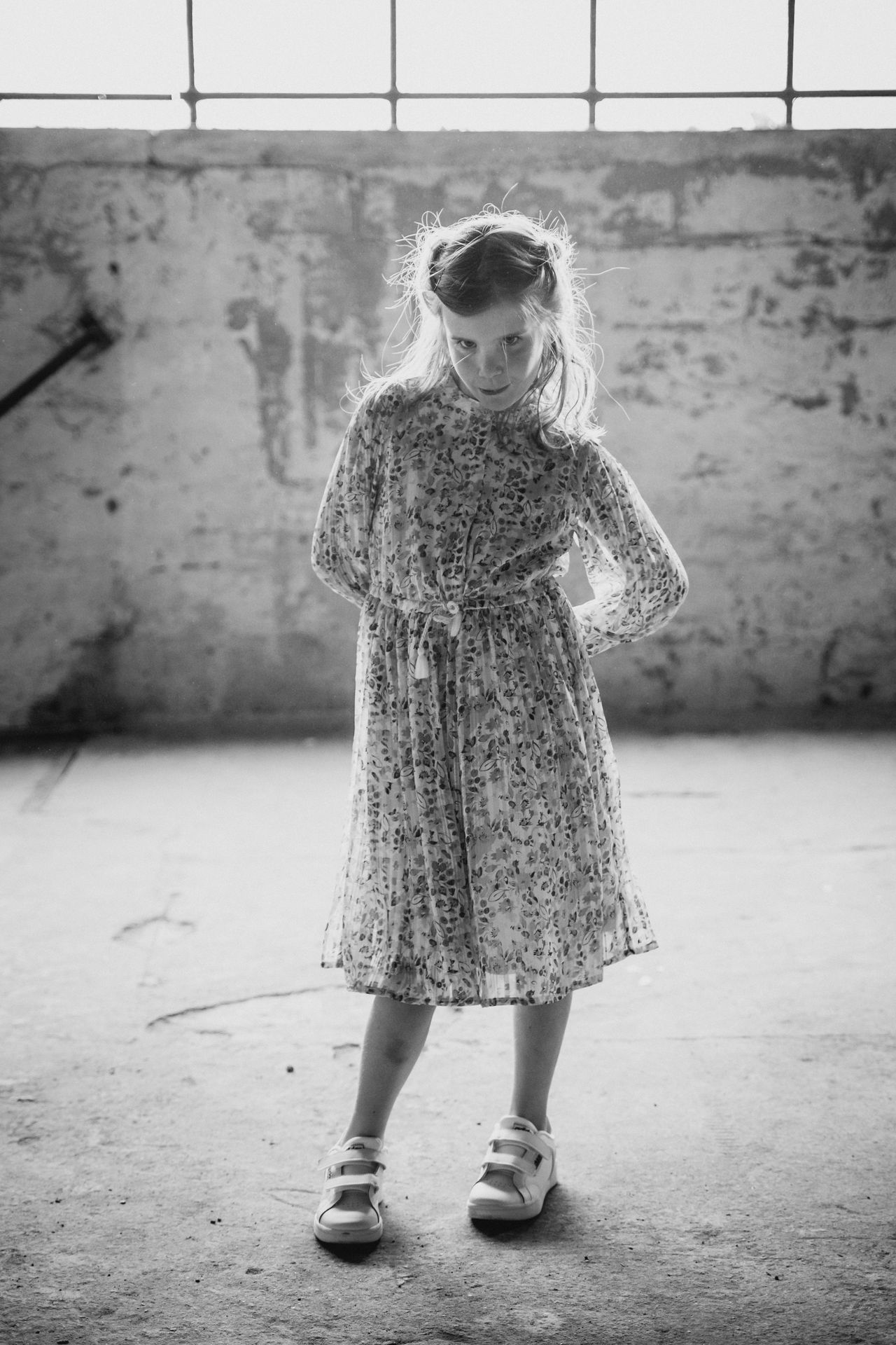 Communiekind in elegante outfit in een oude industriële fabriek