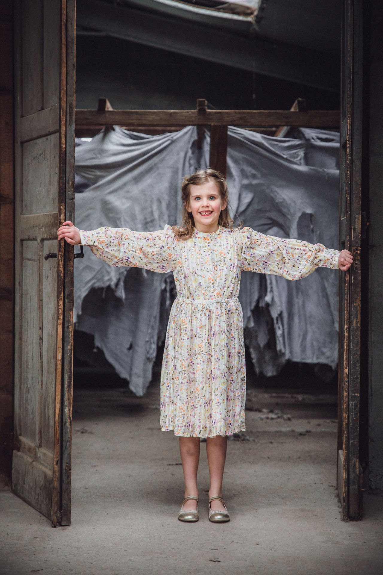 Communiekind in elegante outfit in een oude industriële fabriek