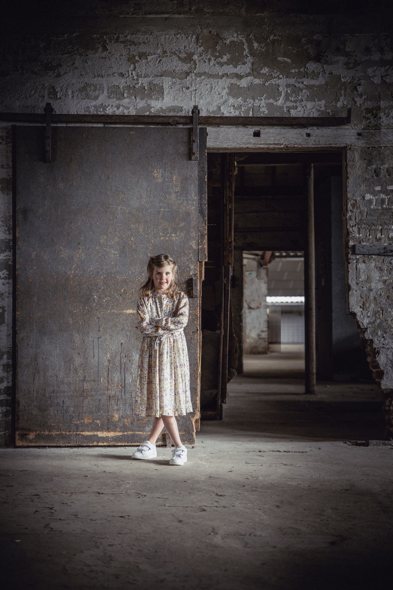 Communiekind in elegante outfit in een oude industriële fabriek