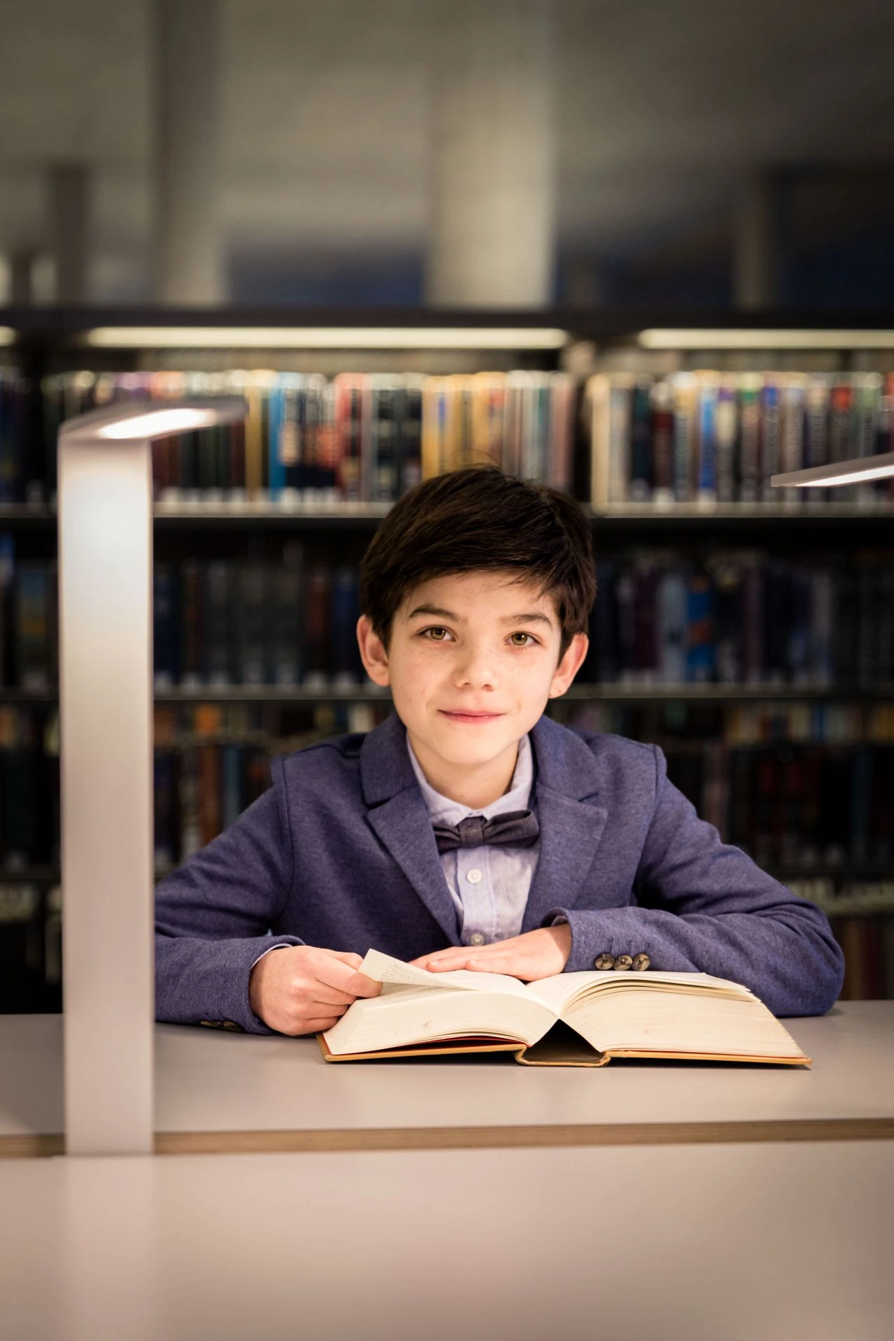 Fotoshoot tussen boekenkasten in bibliotheek met warme sfeer