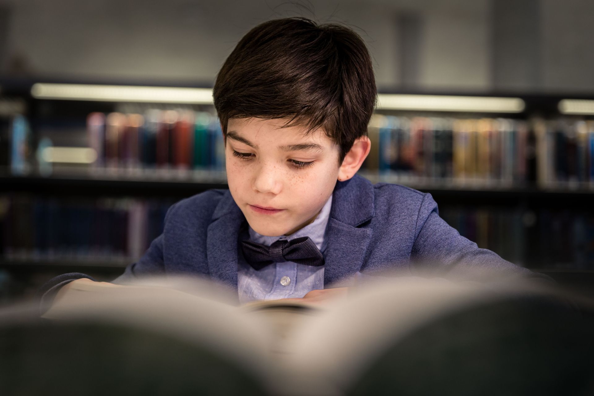 Fotoshoot tussen boekenkasten in bibliotheek met warme sfeer