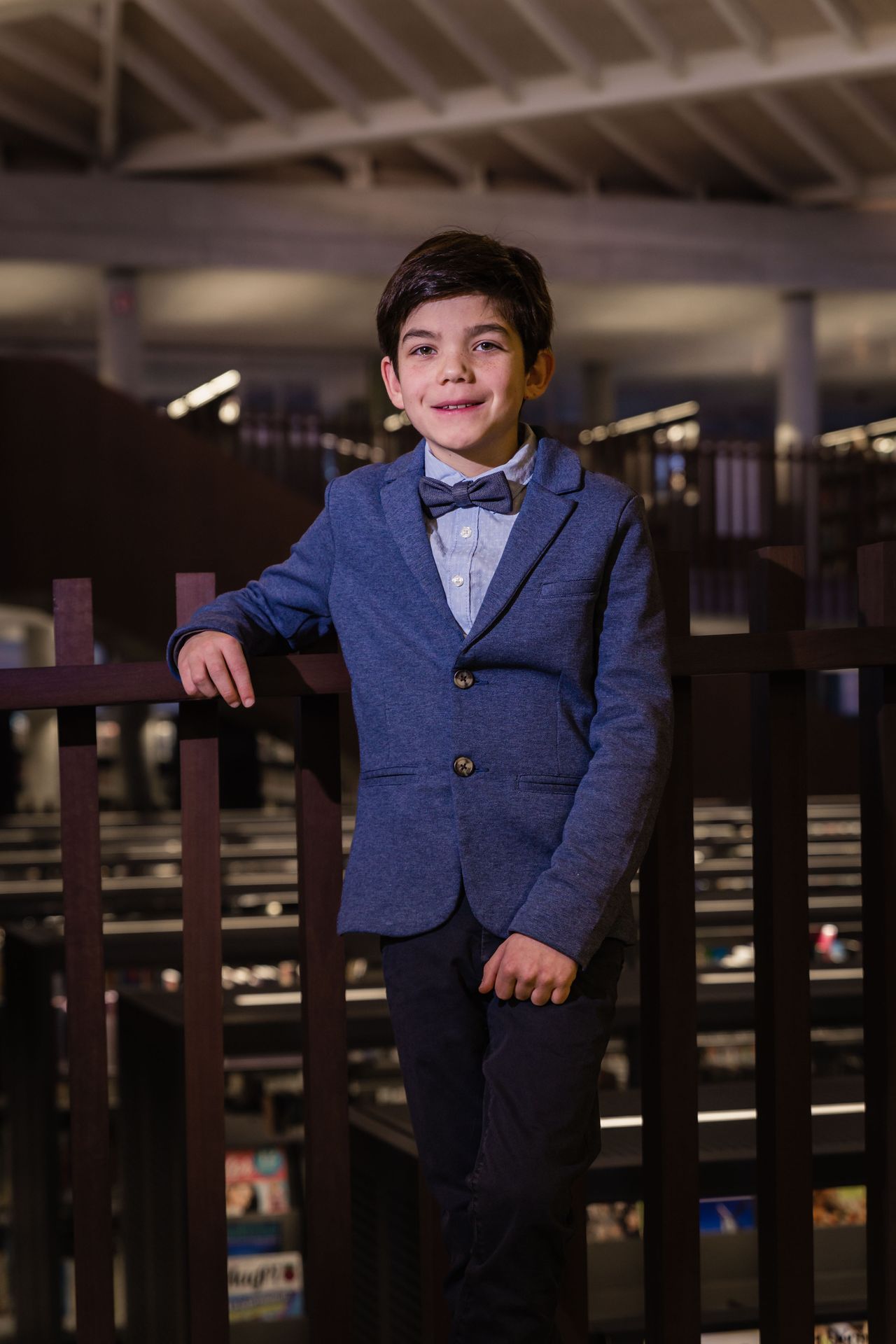 Fotoshoot tussen boekenkasten in bibliotheek met warme sfeer