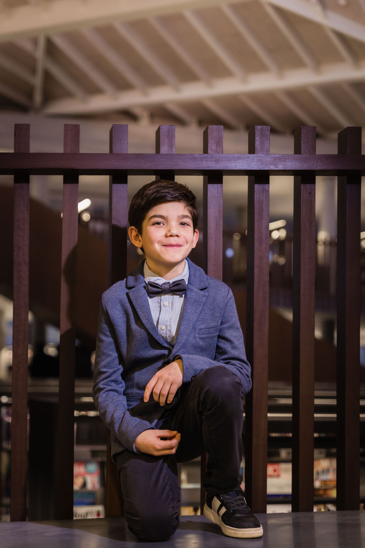 Fotoshoot tussen boekenkasten in bibliotheek met warme sfeer