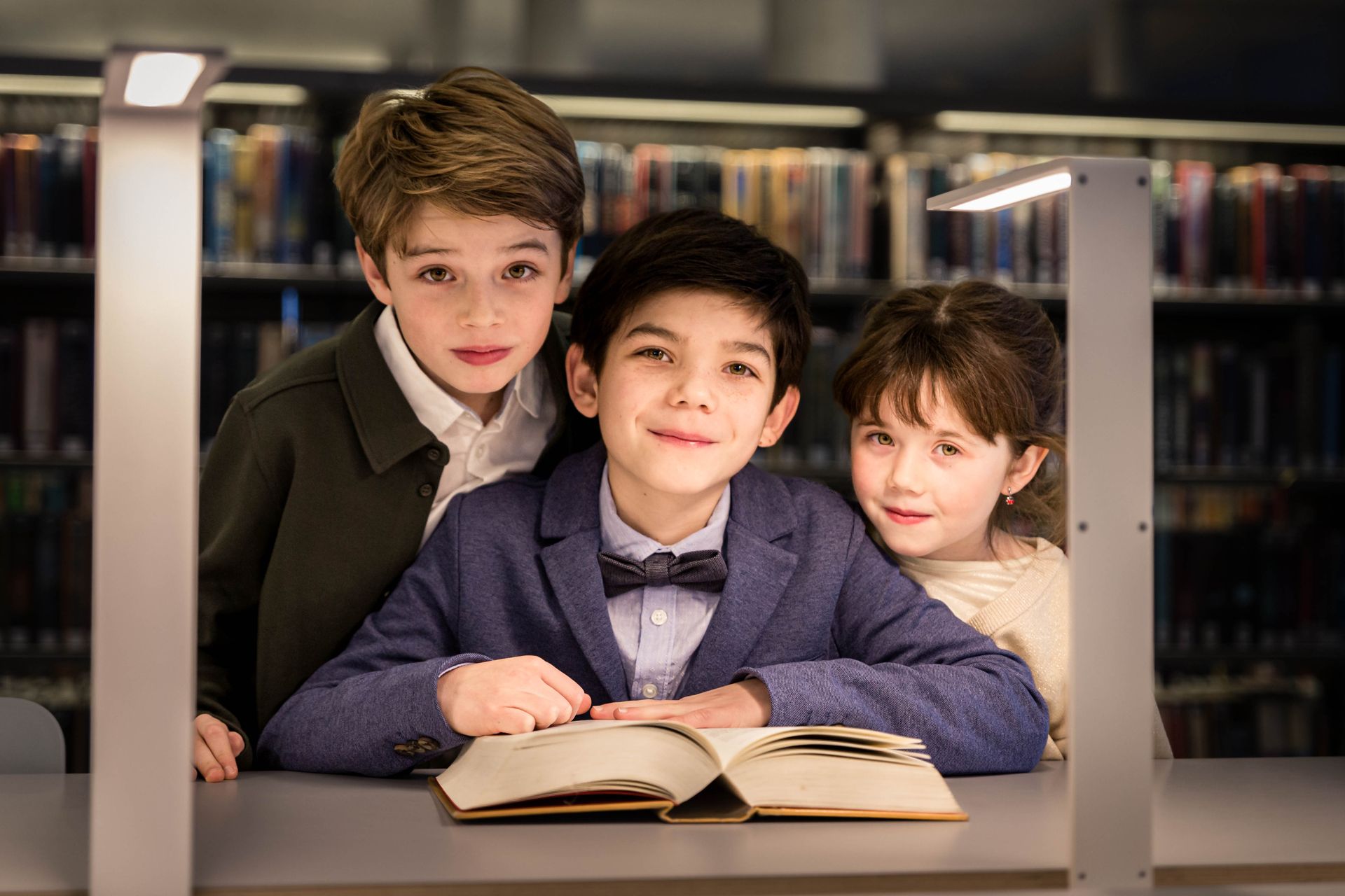 Fotoshoot tussen boekenkasten in bibliotheek met warme sfeer