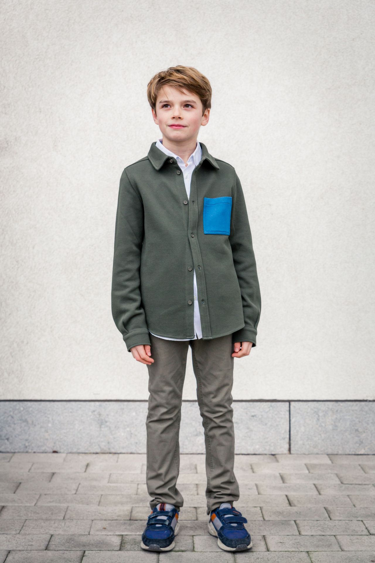 Gezin poseert samen tijdens buitenshoot bij bibliotheek.