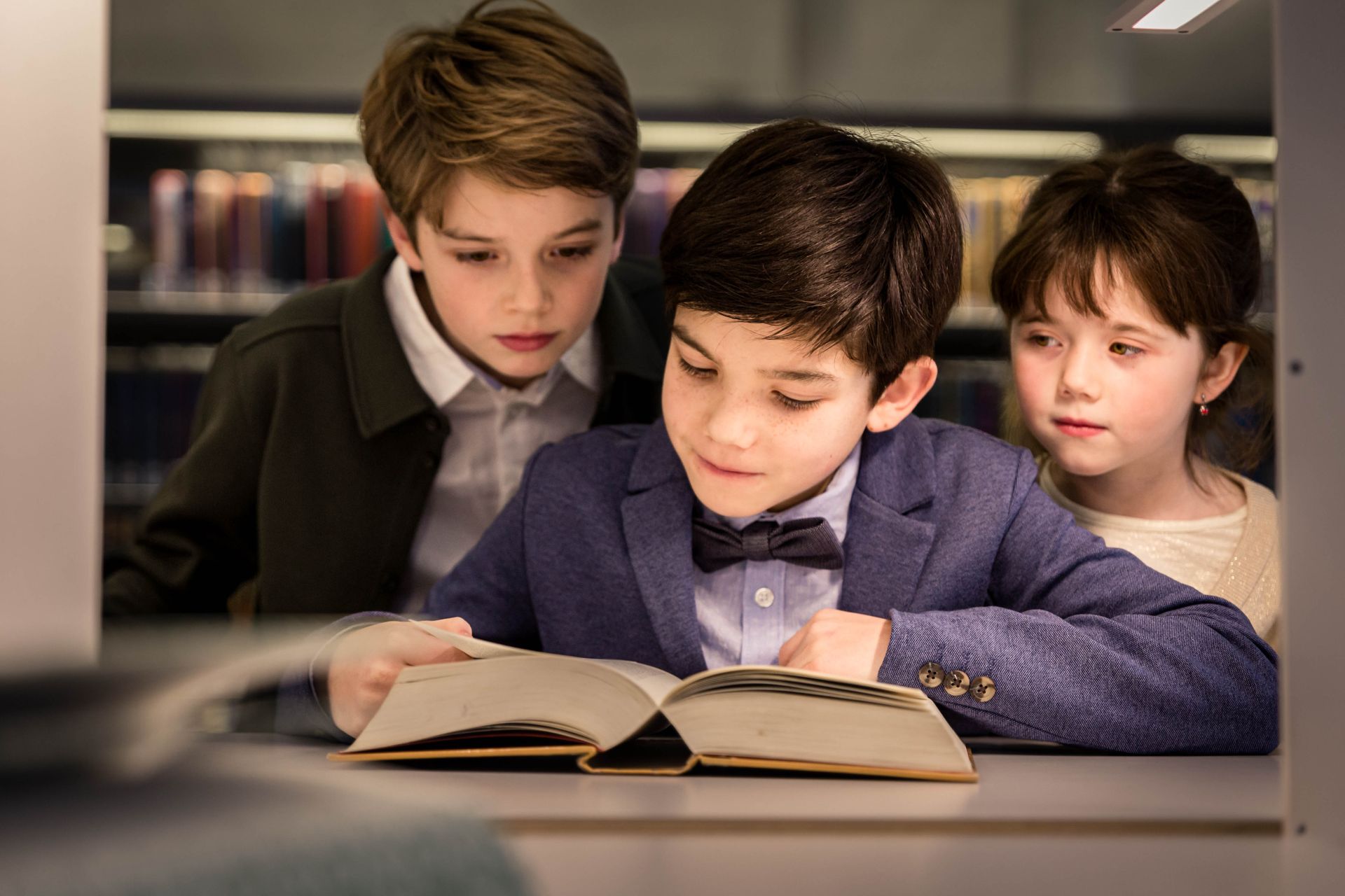 Fotoshoot tussen boekenkasten in bibliotheek met warme sfeer