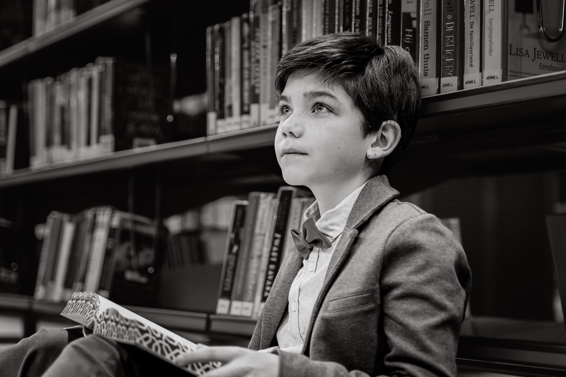 Fotoshoot tussen boekenkasten in bibliotheek met warme sfeer