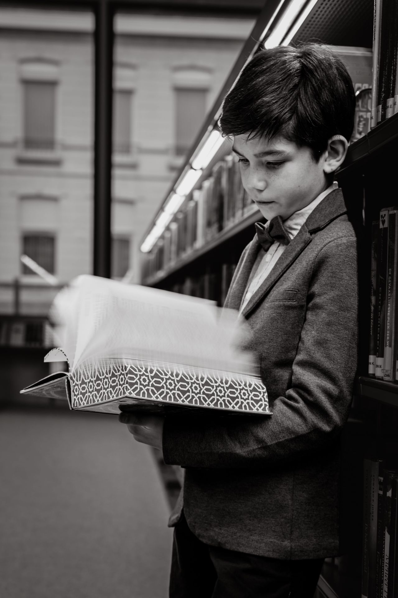 Fotoshoot tussen boekenkasten in bibliotheek met warme sfeer