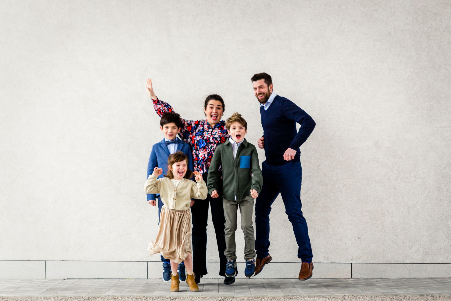 Gezin poseert samen tijdens buitenshoot bij bibliotheek.
