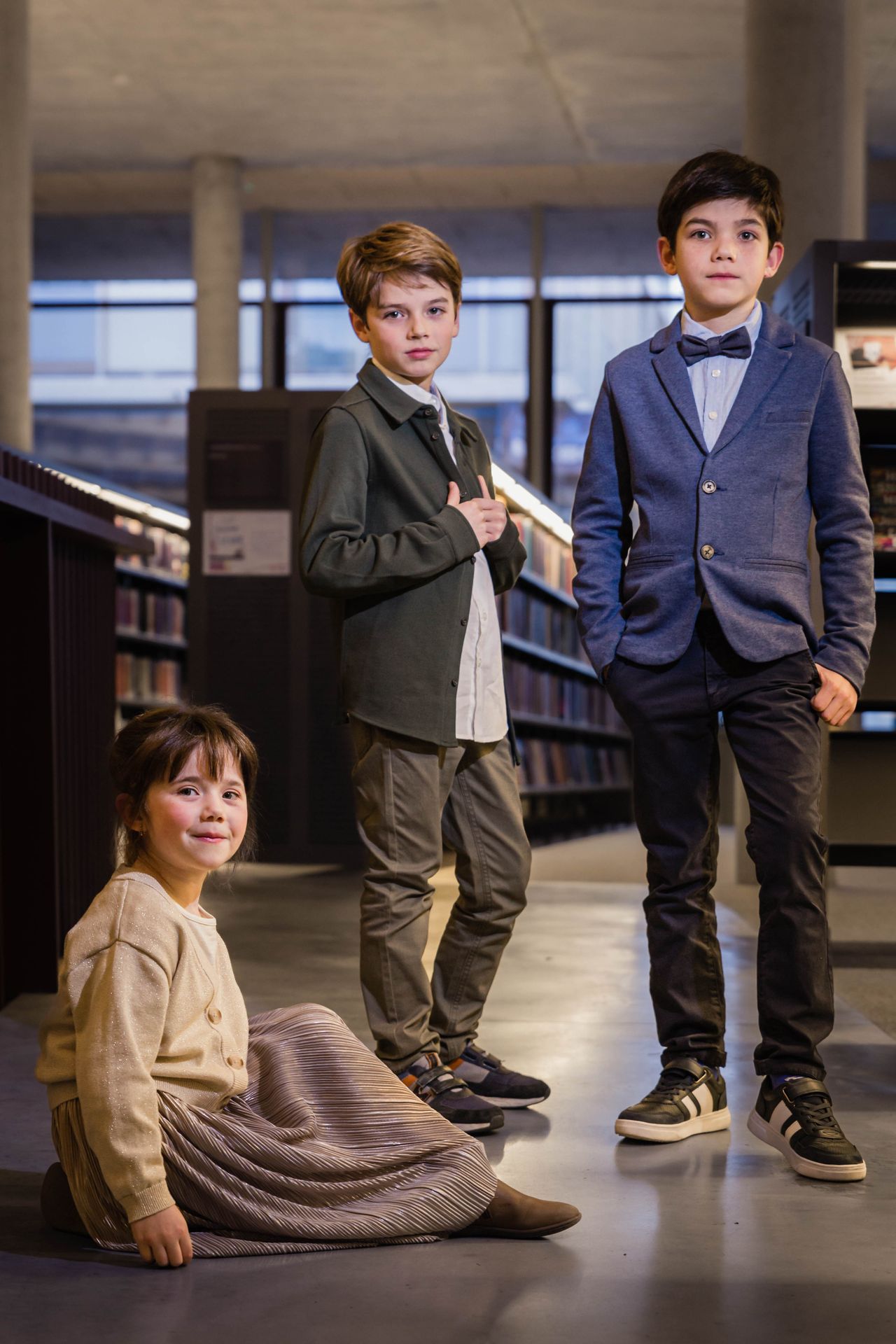 Fotoshoot tussen boekenkasten in bibliotheek met warme sfeer