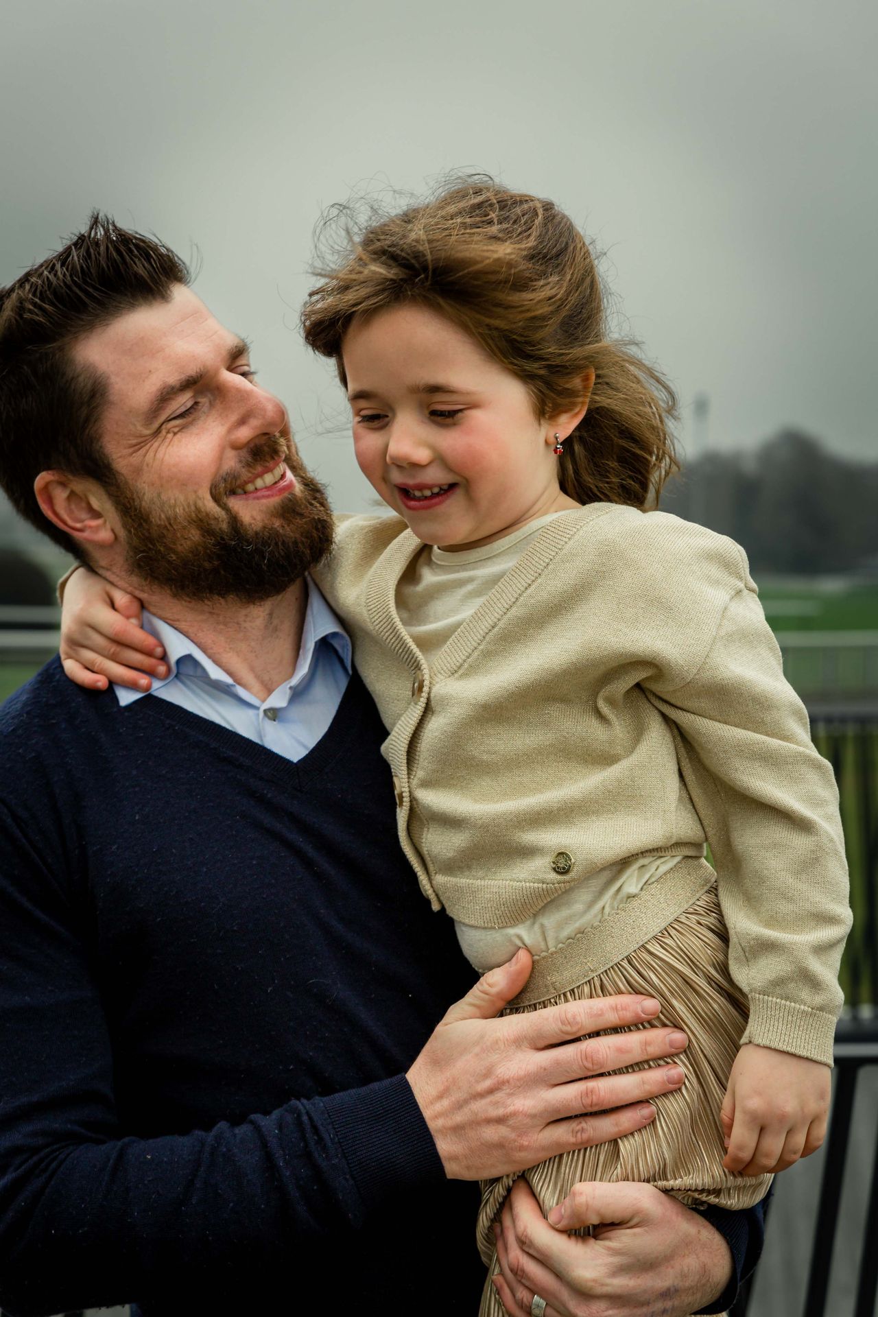 Gezin poseert samen tijdens buitenshoot bij bibliotheek.