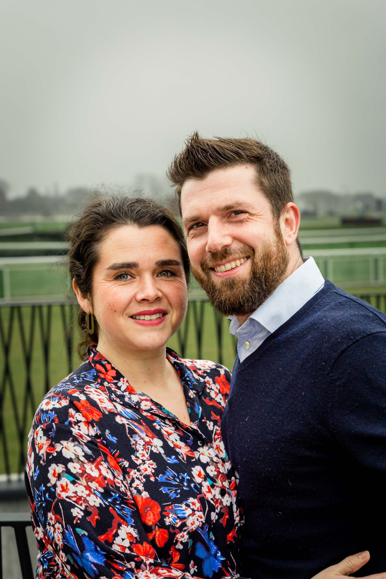 Gezin poseert samen tijdens buitenshoot bij bibliotheek.