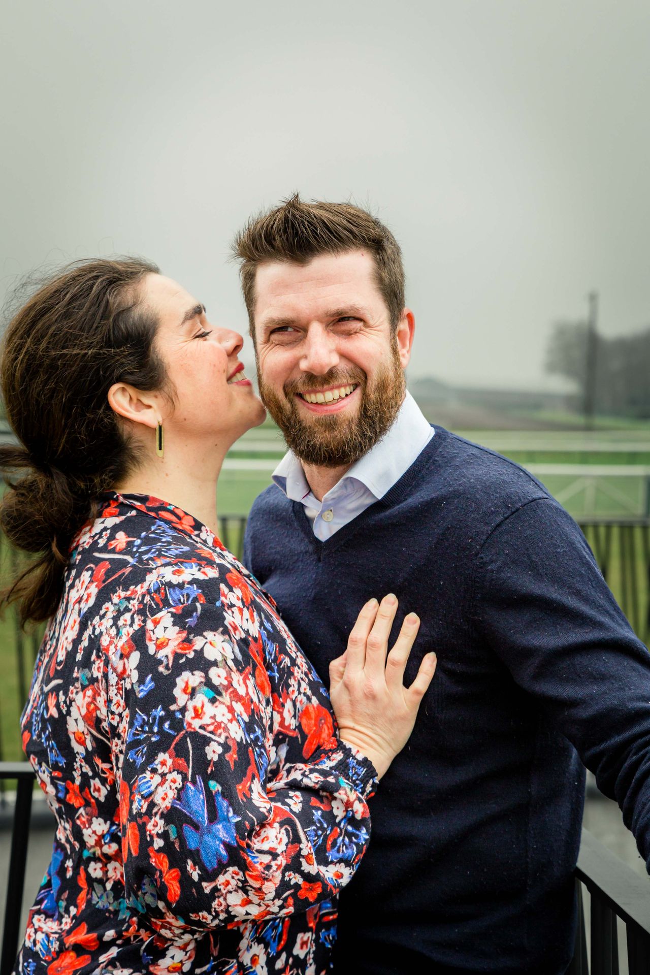 Gezin poseert samen tijdens buitenshoot bij bibliotheek.