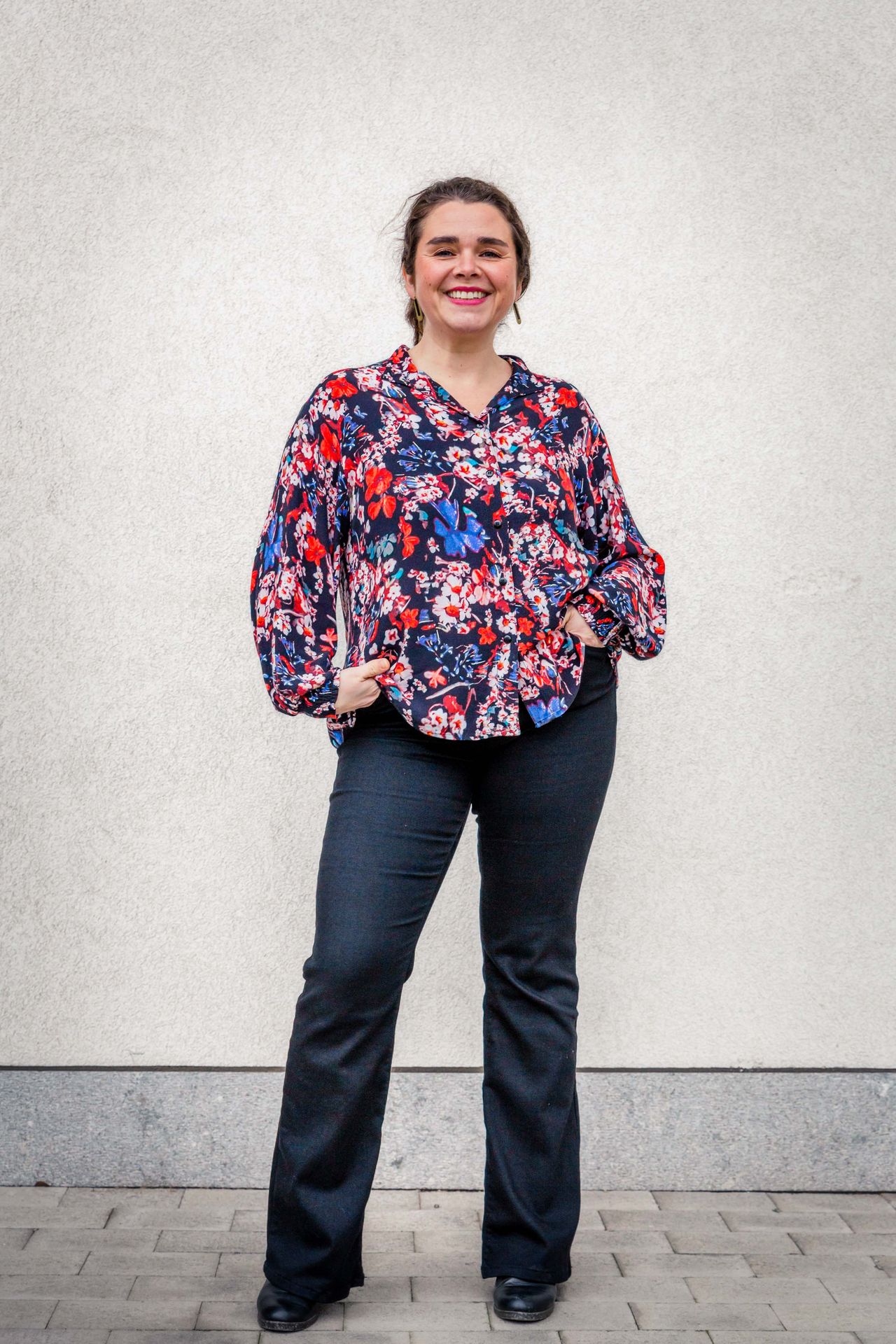 Gezin poseert samen tijdens buitenshoot bij bibliotheek.