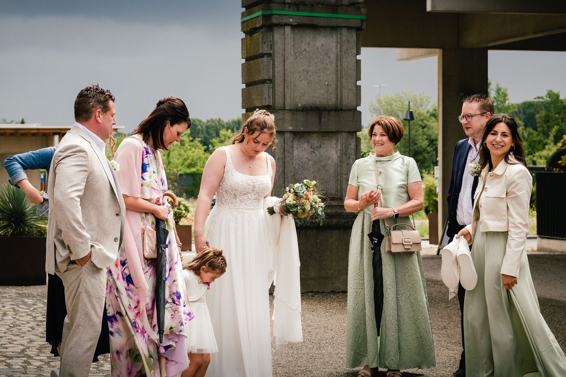 Bruidspaar dat geniet in de regen tijdens hun trouwdag in Plantentuin Meise.
