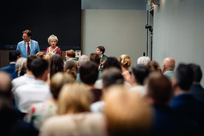 Familielid dat geëmotioneerd toekijkt tijdens het uitspreken van de geloften.