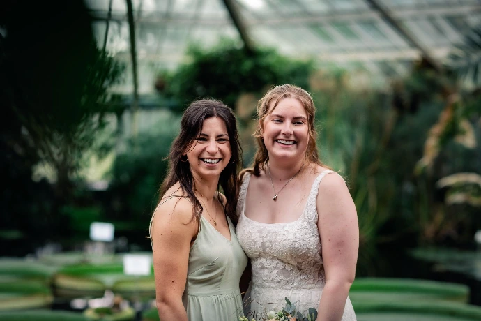 Bruidspaar dat geniet in de regen tijdens hun trouwdag in Plantentuin Meise.