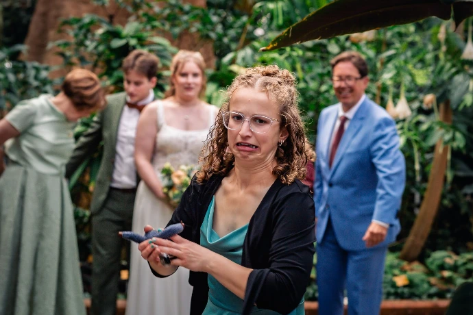 Bruidspaar dat geniet in de regen tijdens hun trouwdag in Plantentuin Meise.