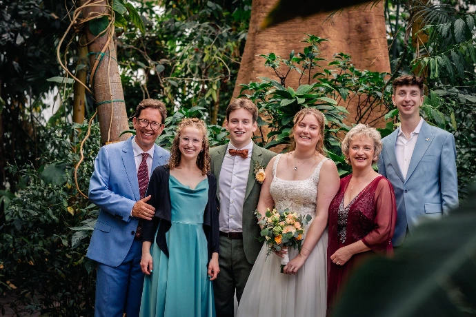 Bruidspaar dat geniet in de regen tijdens hun trouwdag in Plantentuin Meise.