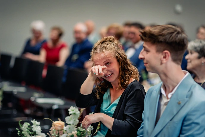 Familielid dat geëmotioneerd toekijkt tijdens het uitspreken van de geloften.