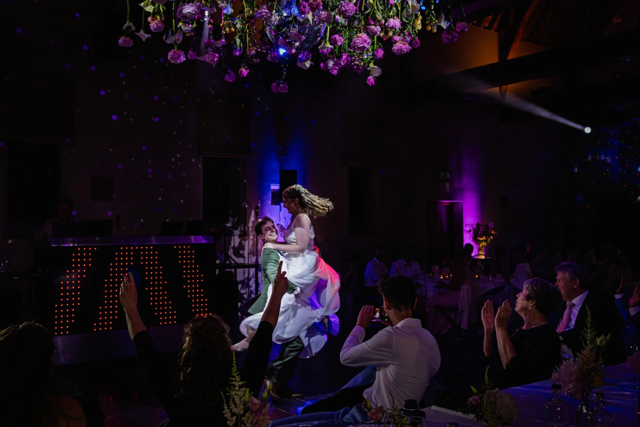 Intieme openingsdans met warm licht en dansende silhouetten.